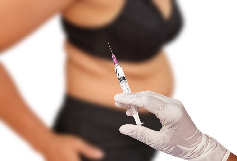 Hand,Holding,Syringe,Concept,Of,Weight,Loss,Surgery,,Liposuction.